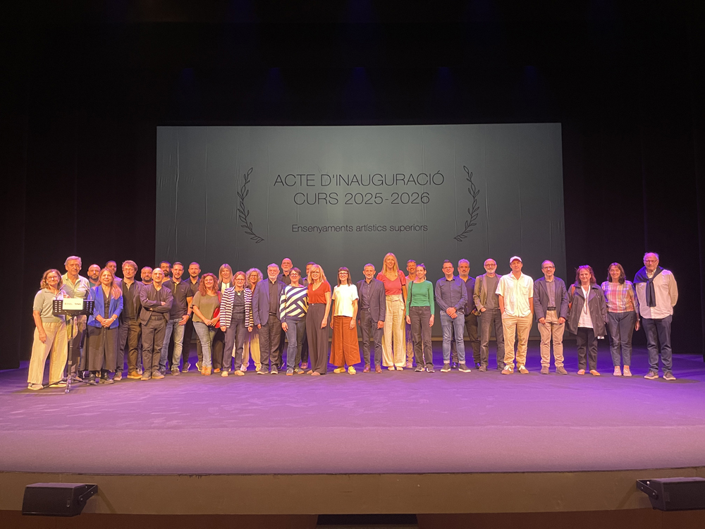 Acte d’Inauguració del curs 2025-26 dels Ensenyaments artístics superiors Fotografia d'un grup nombrós de més de trenta persones, docents i representants de les escoles, drets en línia a l'escenari. Estan posant per a una foto de grup durant l'Acte d'Inauguració del Curs 2025-2026 dels Ensenyaments Artístics Superiors. Tots vesteixen roba casual o informal i somriuen.