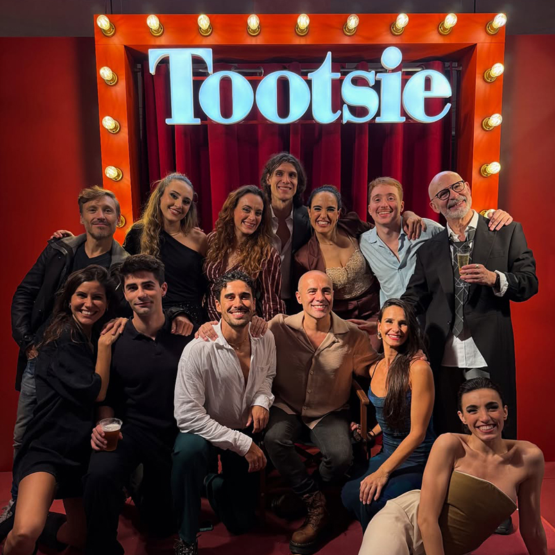 Foto de grup del repartiment i actors del musical 'Tootsie' de Broadway a Barcelona, amb la il·luminació i el cartell del títol darrere, destacant a Sol Carner i a la resta del cast de l'espectacle teatral.